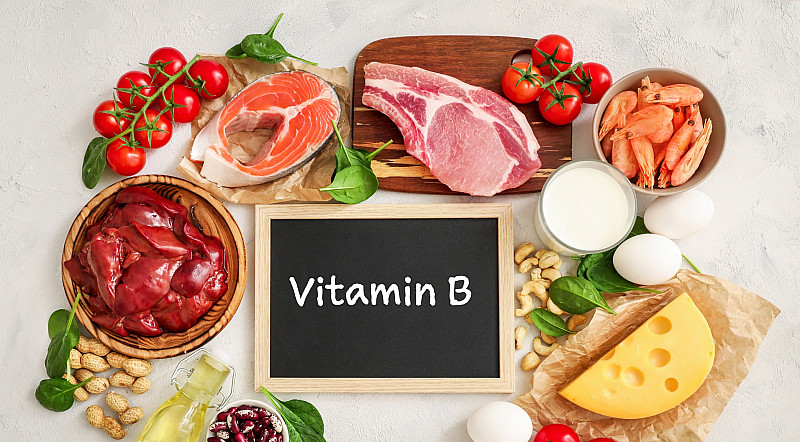 Verschiedene Lebenmittel mit Vitamin B und ein Schild